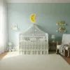Ay dede ahşap gece lambası, yeşil tonlu bebek odasında cibinlikli karyolanın üzerinde ışığı açık sarı hilal