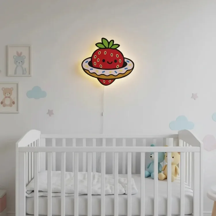 Çilekli gezegen ahşap gece lambası, bulut süslemeli bebek odasında beyaz beşiğin üstünde sıcak ışığı açık halde