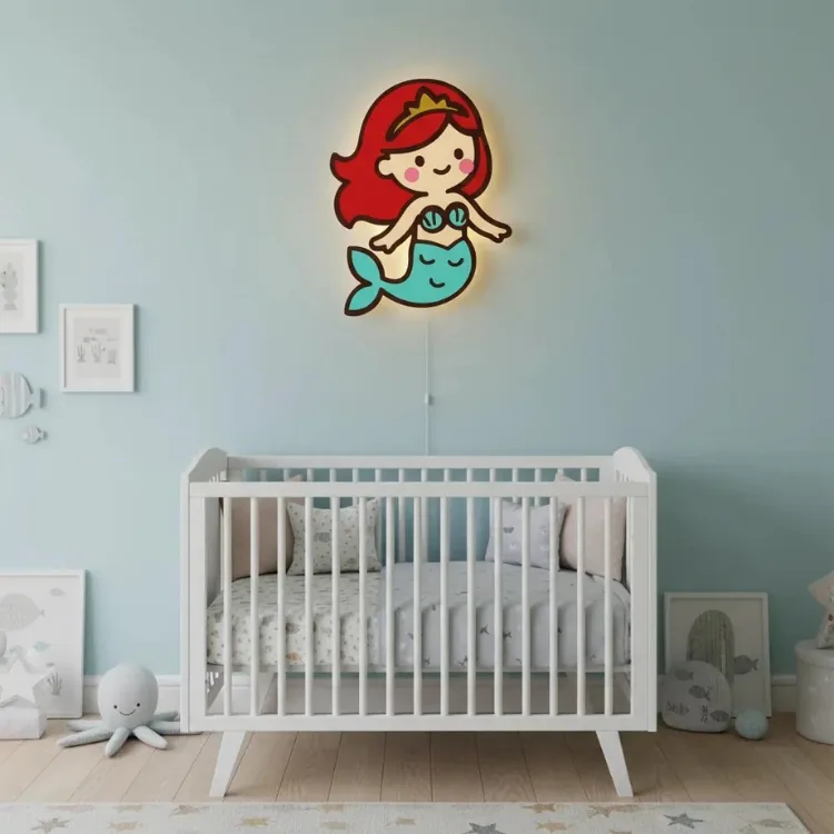 Deniz kızı ahşap gece lambası, ışığı açık halde mavi duvarlı bebek odasında beyaz beşiğin üzerinde