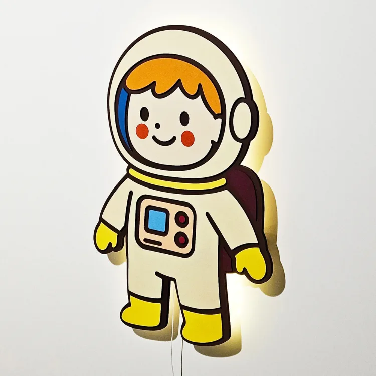 Astronot lamba yandan ve ışığı açık; kask, gülen yüz ve sırt çantasının arkasından duvara yayılan sarı ışık