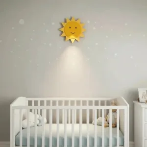 Güneş ahşap gece lambası, yıldızlı gri duvarda beşiğin üstünde; gülen yüzlü sarı güneş ışığı açık halde