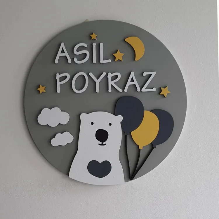 Balonlu ayıcık kapı süsü önden; gri yuvarlak zeminde beyaz isim yazılı, kalpli beyaz ayıcık, lacivert ve hardal balonlar