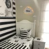İsimli bulut ahşap gece lambası, bebek odasında yatağın üstünde; beyaz bulut üzerinde örnek isim, sıcak ışık açık