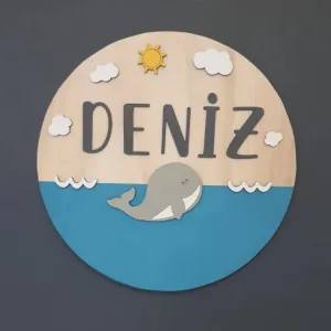 Deniz temalı kapı süsü önden; ahşap üst zemin, mavi deniz, gri balina, beyaz dalga ve bulutlar, antrasit isim yazılı