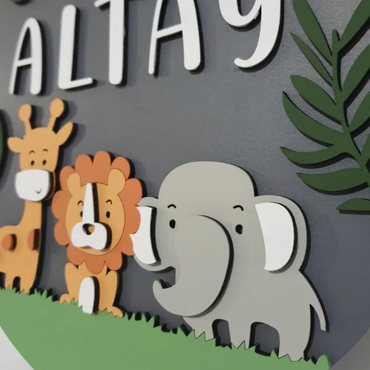 Safari temalı kapı süsünün yandan yakın planı; zürafa, aslan ve filin katmanlı figürleri ile beyaz örnek isim harfleri