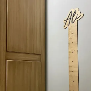 Boy cetveli kahverengi kapının yanındaki duvarda; isim yazılı başlık ve 70 ile 120 cm arası ölçü çizgileri