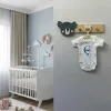 Koala duvar askısı bebek odasında gri duvarda; antrasit koala başı ve askıda isim yazılı beyaz bebek kıyafeti
