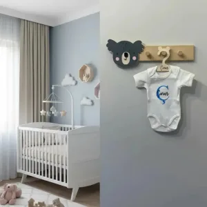 Koala duvar askısı bebek odasında gri duvarda; antrasit koala başı ve askıda isim yazılı beyaz bebek kıyafeti