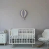 Küçük uçan balon ahşap gece lambası, gri lila duvarda beyaz karyolanın üzerinde mor ve pembe dilimli balon