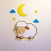 Uyuyan koyun ahşap gece lambası, sarı ışığı açık halde; üstünde sarı ay, mavi bulut ve yıldız figürleri
