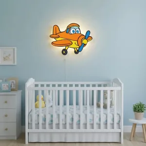 Planör uçak ahşap gece lambası, ışığı açık halde mavi duvarlı bebek odasında beyaz beşiğin üzerinde