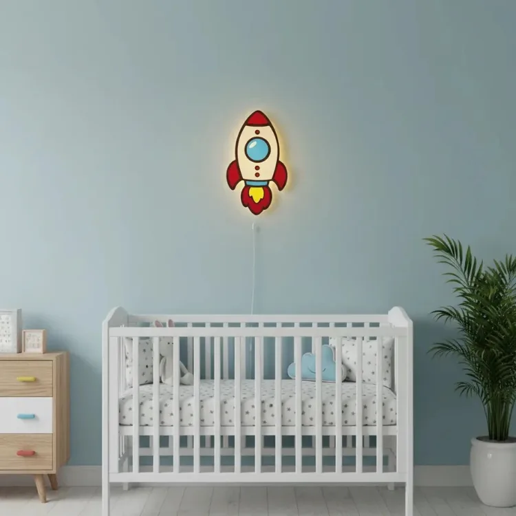 Roket ahşap gece lambası, mavi duvarlı bebek odasında beyaz beşiğin üstünde, sıcak ışığı açık halde