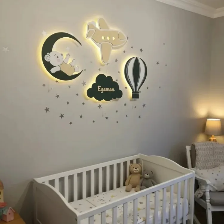 Işıklı bebek ayılı ay, uçak, isim yazılı bulut ve uçan balon lamba, beşikli odanın yıldızlı duvarında