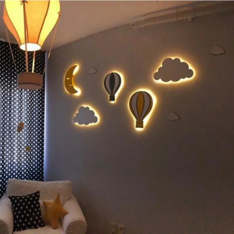 Arkadan ışık veren aydede, uçan balon ve bulut ahşap lambalar, sıcak ışıklı çocuk odası duvarında