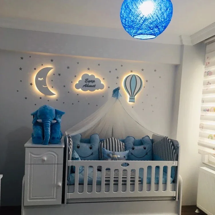 Işıklı aydede, isim yazılı bulut ve uçan balon lamba, mavi tonlu bebek odasında cibinlikli beşiğin üstünde