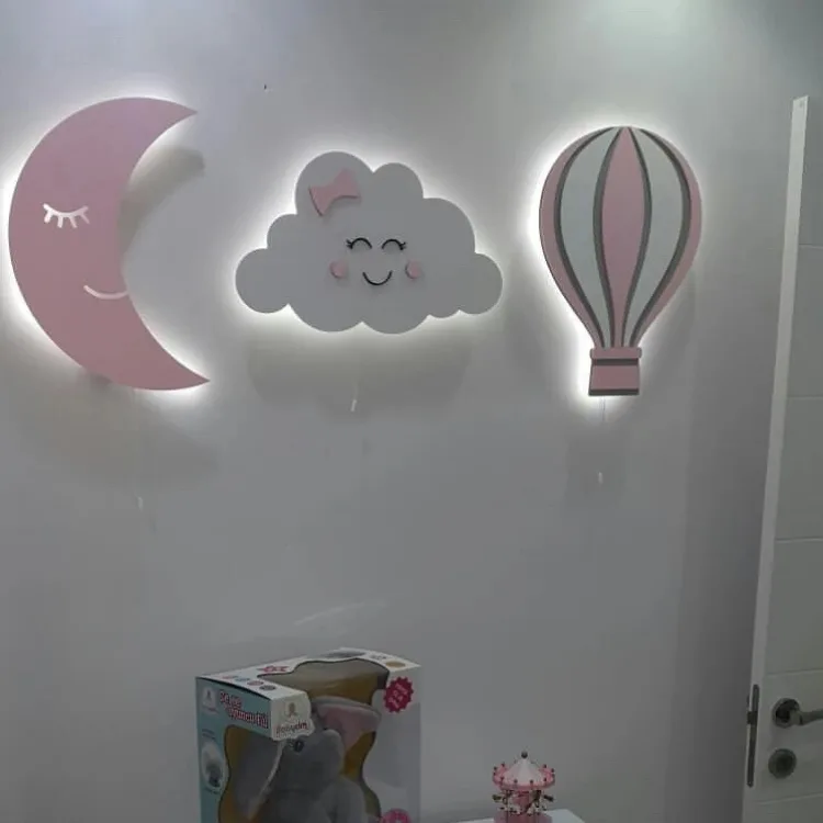 Işığı açık pembe aydede, fiyonklu gülen bulut ve uçan balon ahşap lamba, beyaz duvarda yakından