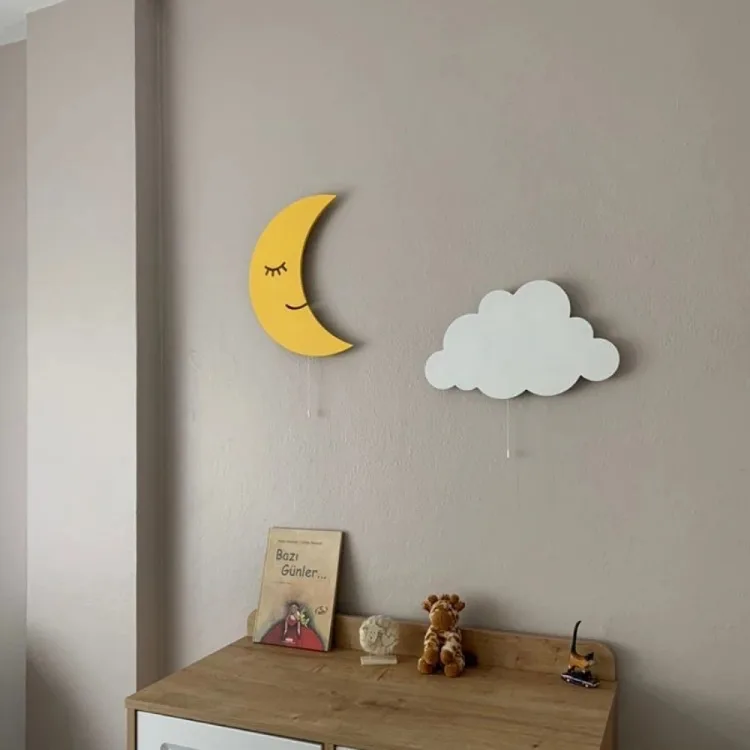 Sarı aydede ve beyaz bulut ahşap lamba, gri duvarda ahşap komodinin üstünde yan yana asılı