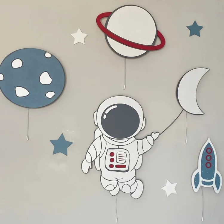 Balon tutan astronot, satürn, ay, roket ve mavi gezegen ahşap lambaları, yıldız süslü duvarda yakından